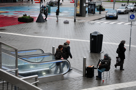 825646 Afbeelding van een straatmuzikant op het Jaarbeursplein te Utrecht, bij de roltrap naar het Stadsplateau.